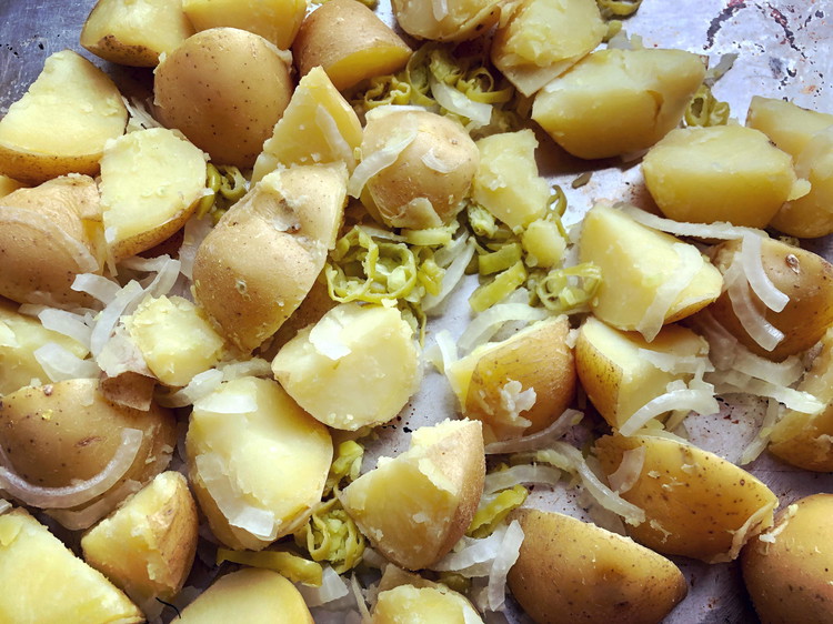 Image of When the potatoes are done drain them and add them to the peppers and onions, stirring well. This will lightly cook the onion pieces and reduce their sharpness.
